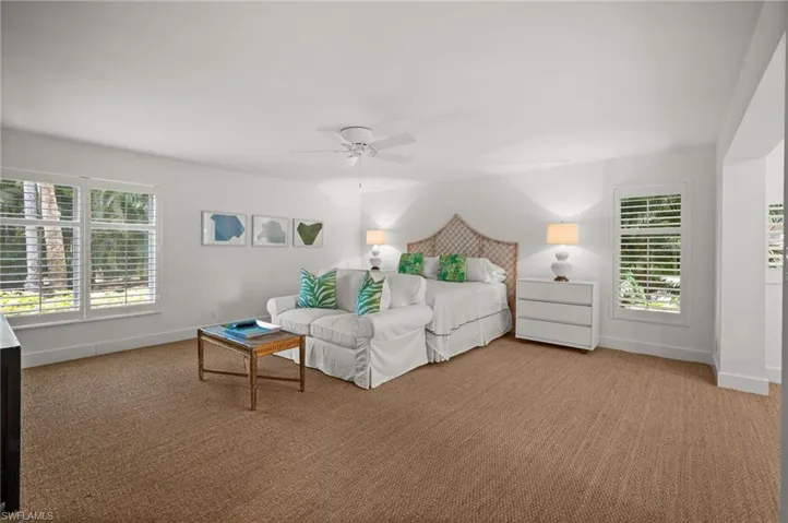 The spacious primary bedroom is light and airy surrounded by windows on three sides.