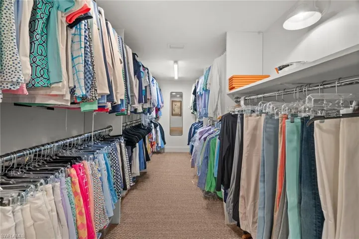 A walk-in primary closet has a terrific amount of  hanging space!