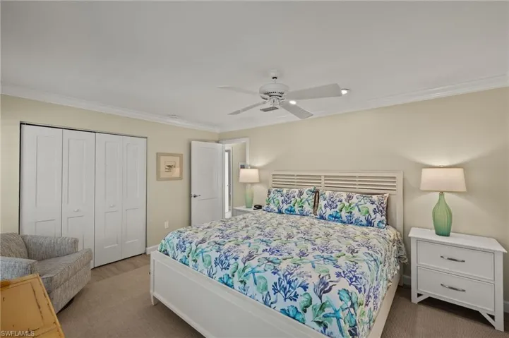 Bedroom featuring ceiling fan, ornamental molding, a closet, and wood finished floors
