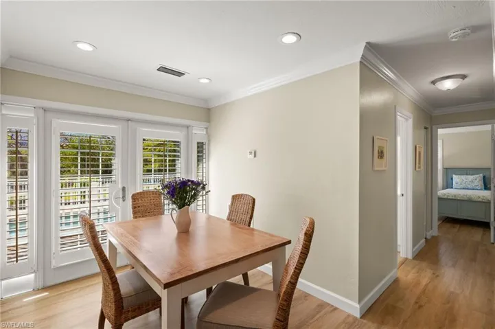 Dining area with french doors, ornamental molding, light wood-type flooring, and visible vents