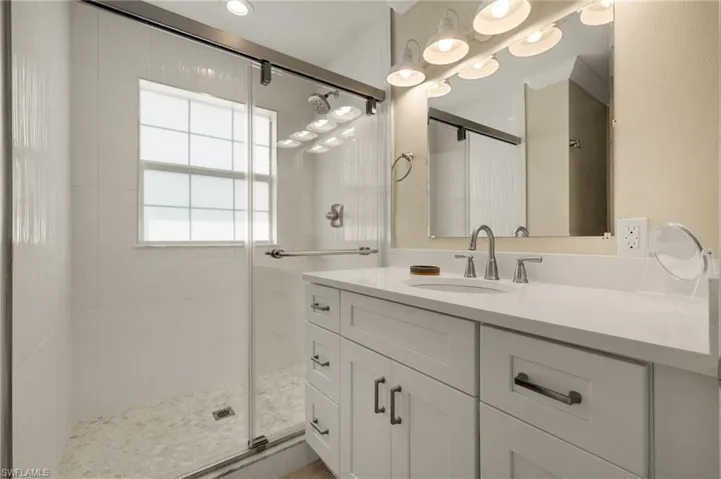 Bathroom featuring a shower stall and vanity