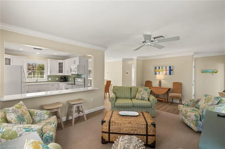Living area featuring crown molding, visible vents, and wood finished floors