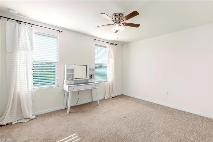 Unfurnished room featuring light carpet and baseboards