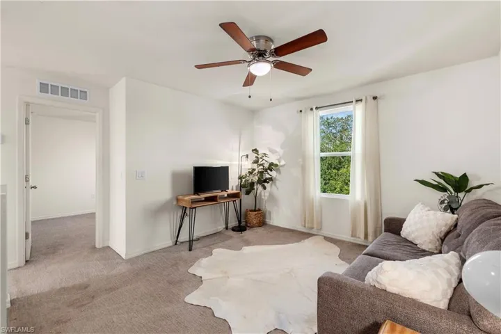 Living room with carpet flooring and ceiling fan