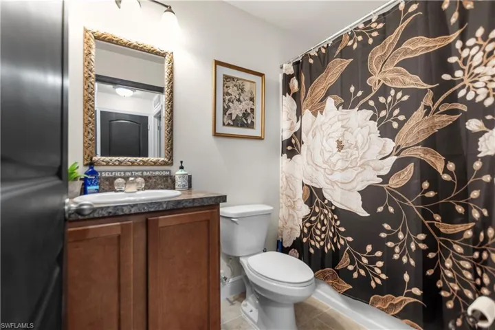 Bathroom featuring double vanity, a shower with curtain, and light wood finished floors