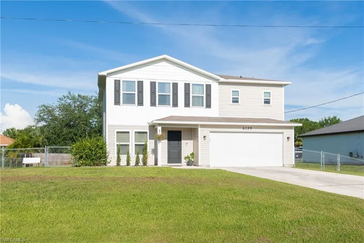 Traditional-style home featuring an attached garage and concrete driveway