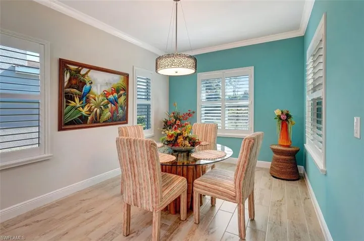 The dining room welcomes ample space, planked flooring, dual colored walls & colorful accessories.