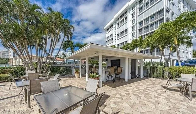 Poolside terrace with outdoor kitchen and bar.