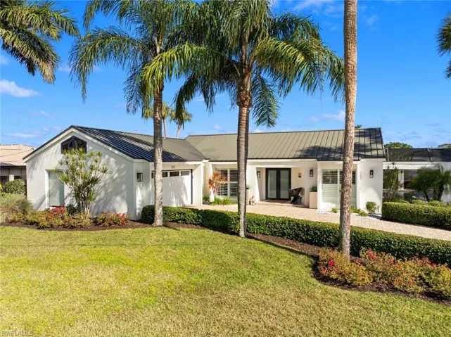 Ranch-style house featuring a garage and a front lawn