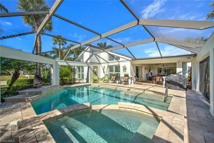 View of swimming pool with an in ground hot tub, a lanai, area for grilling, and a patio