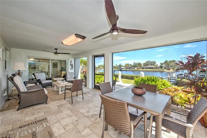 Sunroom with ceiling fan and a water view