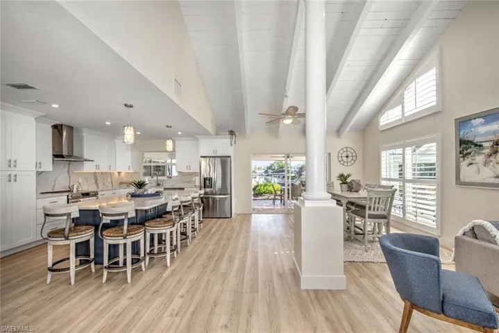 Dining area with decorative columns, plenty of natural light, ceiling fan, and beamed ceiling