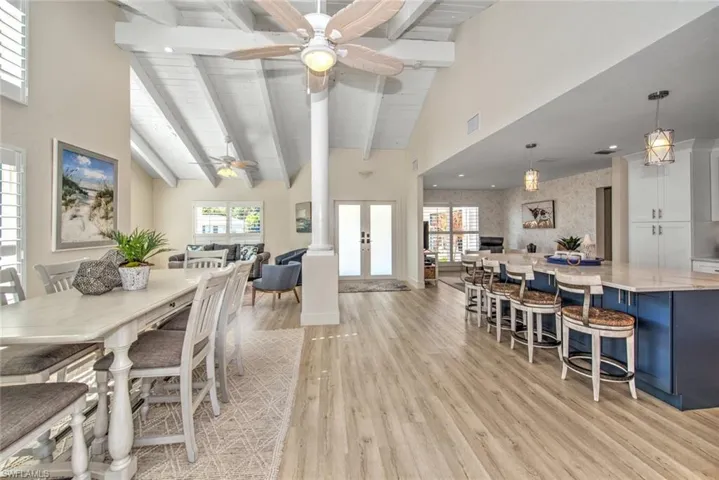 Dining space featuring french doors, a healthy amount of sunlight, beam ceiling, and light hardwood / wood-style flooring