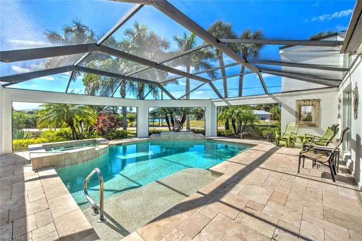 View of swimming pool with an in ground hot tub, a lanai, and a patio area