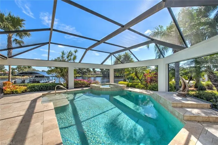 View of swimming pool with a lanai, an in ground hot tub, a patio, and a water view
