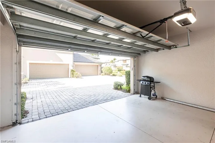 Garage featuring a textured wall and a garage door opener