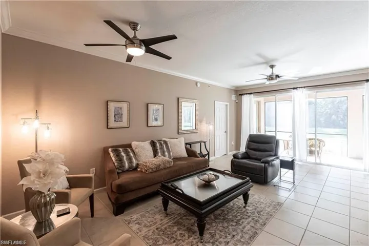 Living area with crown molding, ceiling fan, and tile patterned floors