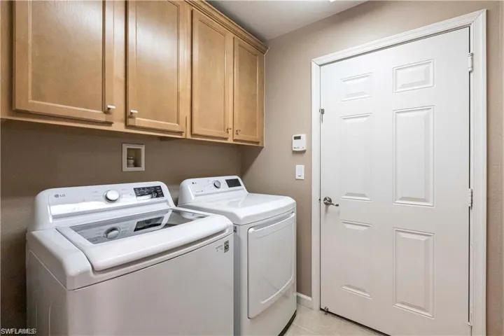 Laundry room featuring washer and clothes dryer and cabinet space