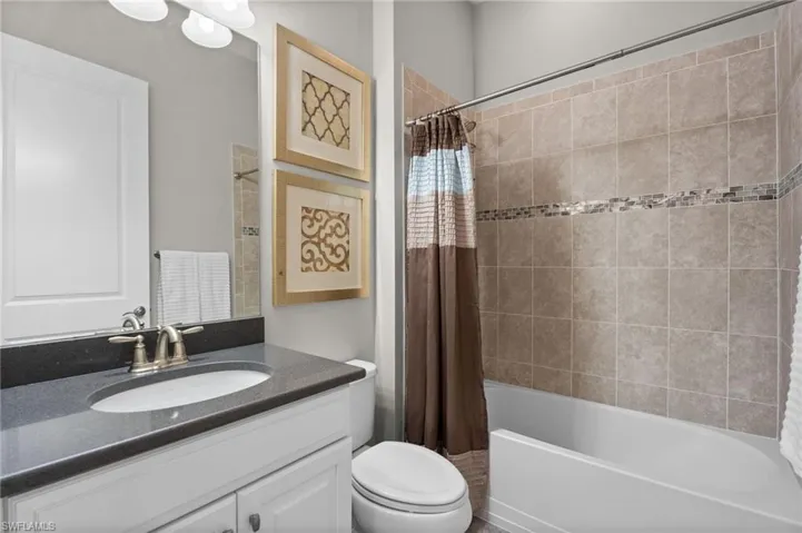 Full bath featuring vanity and shower / tub combo with curtain