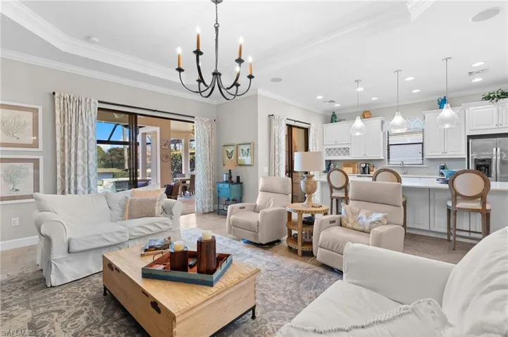 Living area with ornamental molding and suspended lighting