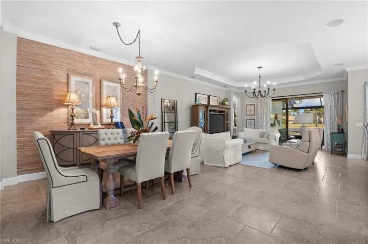 Dining space featuring hanging lights and crown molding