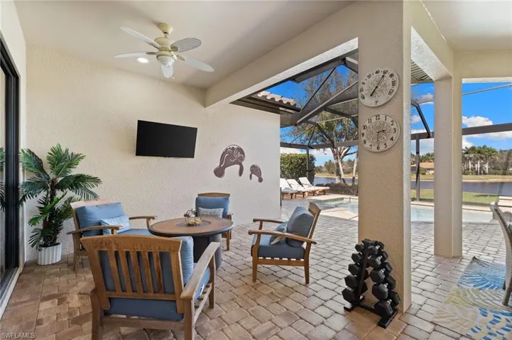 View of patio / terrace featuring a lanai, ceiling fan, a sunroom, an outdoor pool, and outdoor furniture