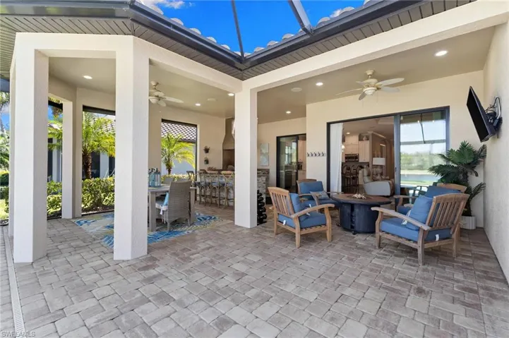 View of patio / terrace with ceiling fan, an outdoor bar and dining area, and an outdoor fire pit