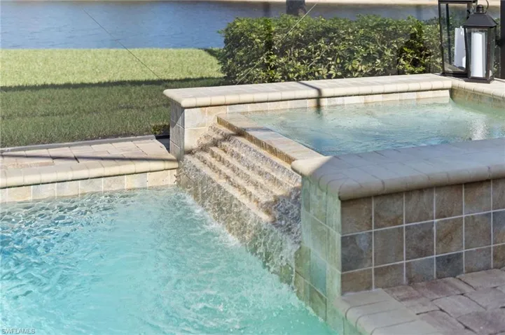 View of swimming pool with a swimming pool, an in-ground hot tub, and a water view