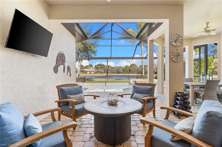 View of patio featuring a sunroom, a lanai, a ceiling fan, an outdoor pool, and outdoor dining space
