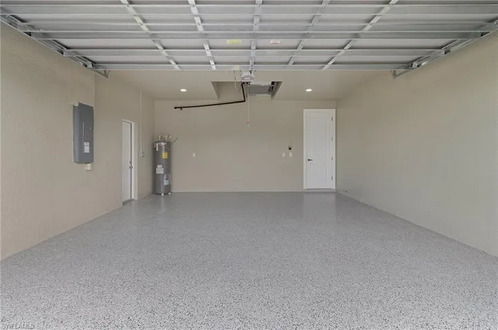 Garage featuring electric panel and electric water heater