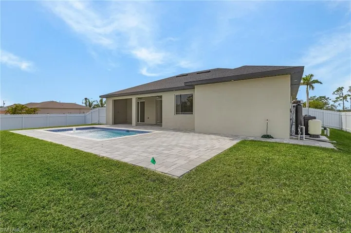Rear view of house featuring a patio area, stucco siding, a fenced backyard, and roof with shingles