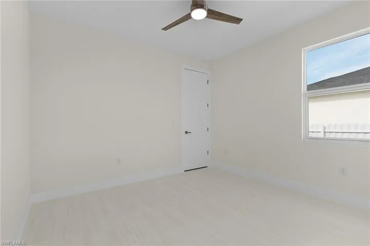 Empty room featuring light wood-style flooring and ceiling fan