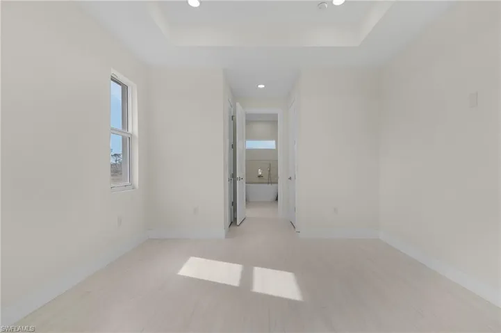 Unfurnished room featuring recessed lighting and a tray ceiling