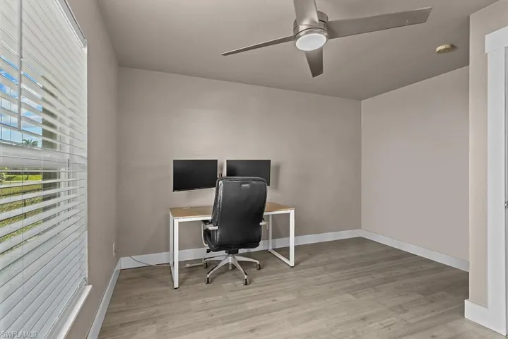 Office space with wood finished floors, ceiling fan, and baseboards