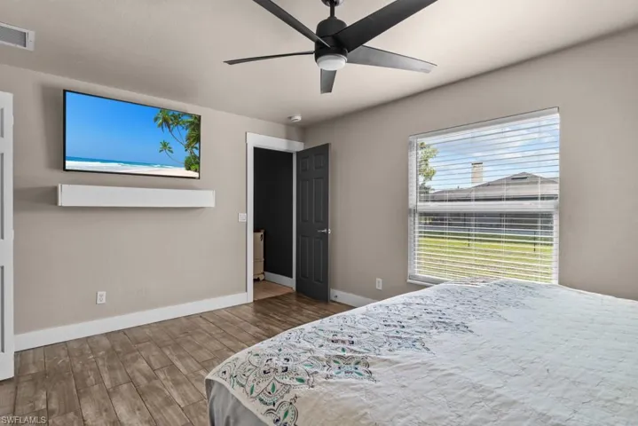 Bedroom featuring wood finished floors, baseboards, and ceiling fan