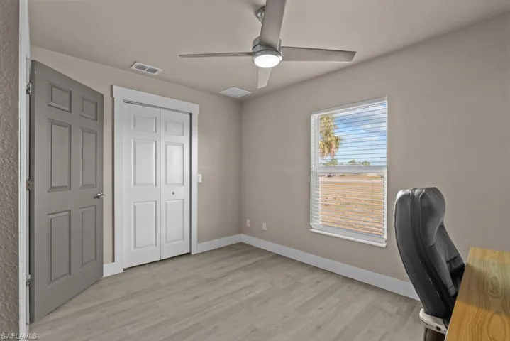 Unfurnished office featuring ceiling fan, light wood-style floors, and baseboards