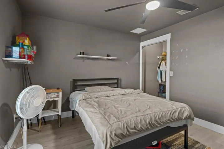 Bedroom with wood finished floors, ceiling fan, and baseboards