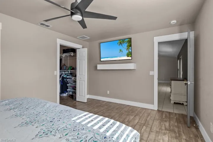 Bedroom with wood finished floors, a closet, baseboards, and ceiling fan