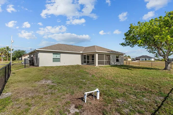 Back of house featuring a sunroom and stucco siding