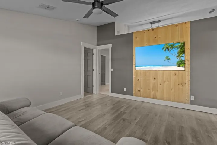 Living room with wood finished floors, ceiling fan, and baseboards