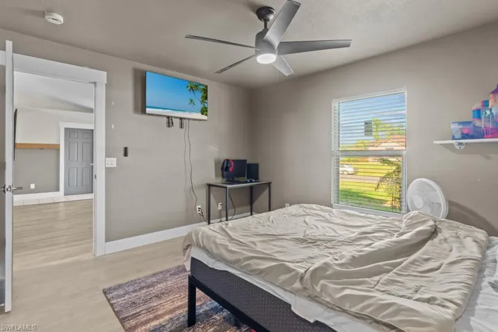 Bedroom featuring wood finished floors, baseboards, and ceiling fan
