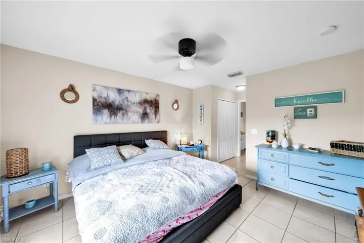 Bedroom featuring ceiling fan, a closet, and light tile patterned floors