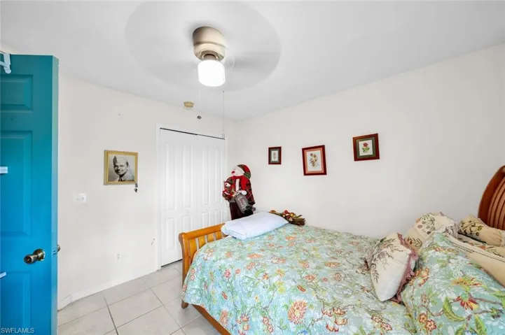 Bedroom with ceiling fan, a closet, and light tile patterned floors