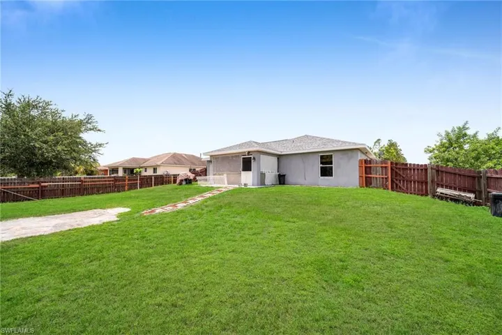 Back of property with a lawn