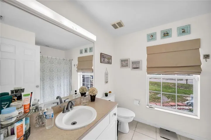 Bathroom featuring tile patterned flooring, vanity, and toilet