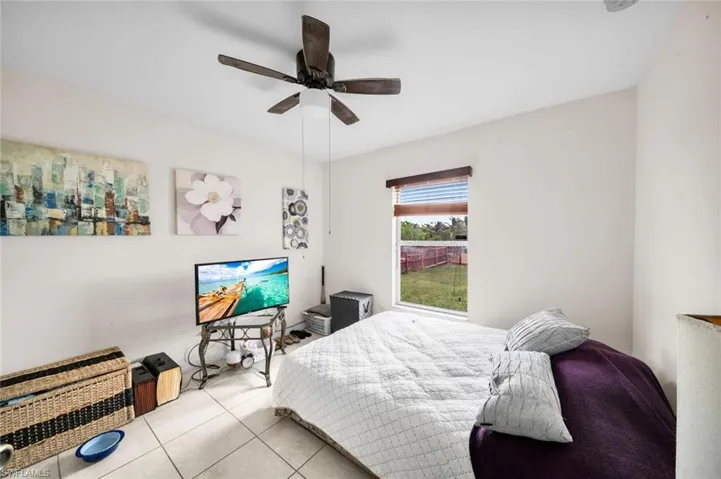 Bedroom with ceiling fan and light tile patterned flooring