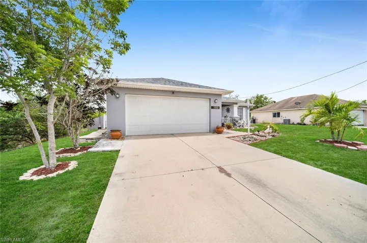 Ranch-style house featuring a garage and a front yard