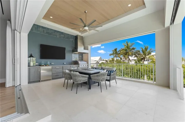 View of patio featuring area for grilling, a grill, outdoor dining space, and ceiling fan