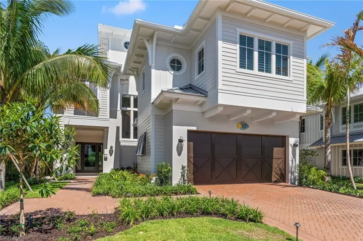View of front of property with a garage, decorative driveway, a standing seam roof, stucco siding, and metal roof