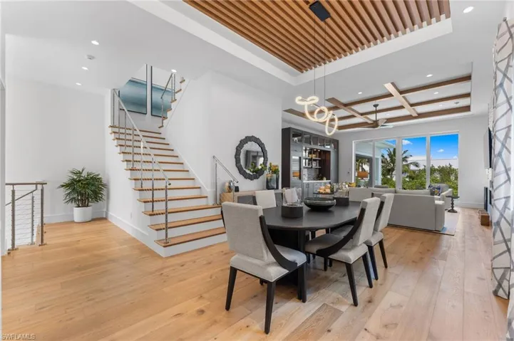 Dining room with recessed lighting, baseboards, hardwood / wood-style flooring, a chandelier, and stairway